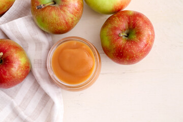 Jar with sweet apple jam on light background