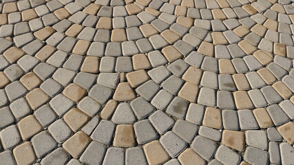 a fragment of a paved street surface with light stone cobblestones with rounded edges, a full-frame graphic resource with a stone space of a relief texture with arched masonry in gray-beige tones