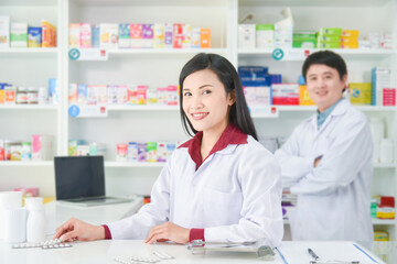 Asian professional young pharmacists standing with smile at drugstore.