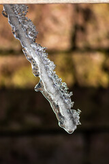 Long icicles melting in winter and spring from December to January  as frozen water with frosty ice as slippery crystals on urban streets and beautiful winter scenery show need for weather insurance