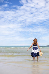 Fototapeta na wymiar Woman barefoot walking on summer along wave of sea water and sand on the beach.