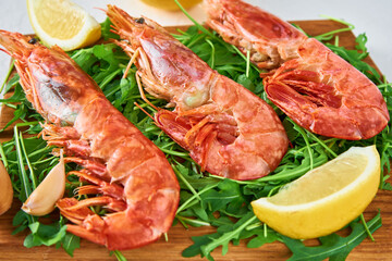 Red raw prawns, close up. Fresh shrimps with lemon and rucola. Seafood background
