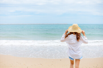 Fototapeta na wymiar young woman wearing sun hat on the beach. summer, holidays, vacation, travel concept
