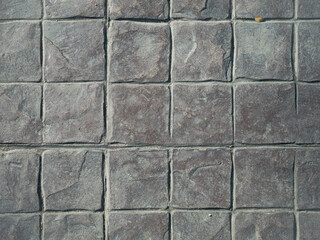 Concrete paving stone pattern texture. Covering the sidewalk. Square tiles.