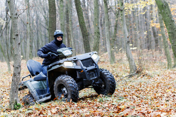 Travel without roads. ATV. A man rides through the forest on an all-terrain vehicle. Quad bike. In the woods. ATV trip to the forest © nazariykarkhut