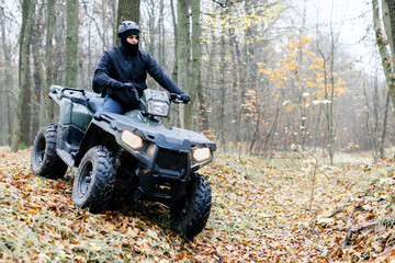 Travel without roads. ATV. A man rides through the forest on an all-terrain vehicle. Quad bike. In the woods. ATV trip to the forest © nazariykarkhut