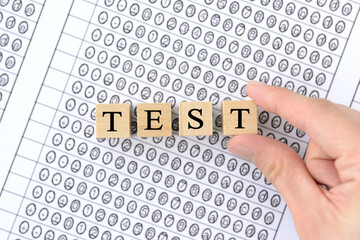 マークシート用紙に置かれたTESTの文字ブロック