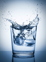 Ice falling into a glass, splashing water