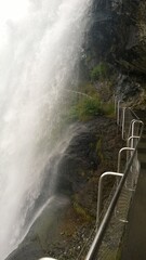 waterfall in the mountains next to the footpath