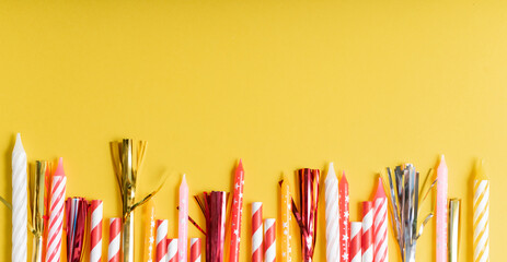 yellow birthday flatlay. colored paper tubes with wax candles. holiday concept, greeting card....