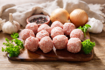 fresh raw meatballs with ingredients for cooking