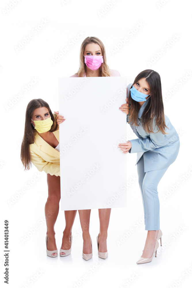 Poster Three women in pastel suits holding billboard posing over white background