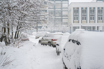 Cars in the yard of house during heavy snowfall in Russia