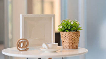 Coffee table with coffee cup, plant pot and mock up frame in leisure corner