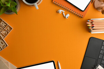 Artist workspace with stationery, craft element, digital device and copy space on yellow table
