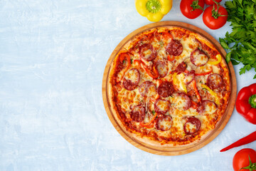Delicious pizza with sausages on gray background