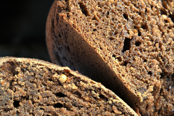 Homemade freshly baked Borodino bread with coriander and cumin on a black background closeup