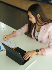 Businesswoman working with digital tablet and business document