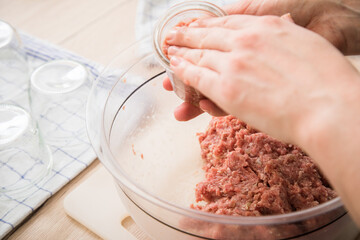 Frau füllt Hackfleisch aus Schwein und Rind roh in Einkochglas und Weckglas zum Einkochen Einwecken selbdstgemacht in Küche für Haltbarkeit und Vorrat
