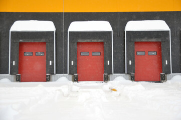 The empty loading bay of a large warehouse is covered with snow in winter.