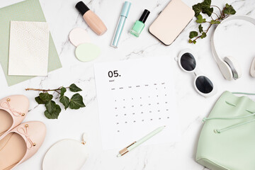 Flat lay with calendar for may with woman fashion spring accessories.