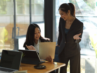 Fototapeta premium Two businesswomen consulting on their project while working in office room