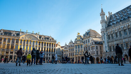 Fototapeta premium View of the Grand Place in Brussels in winter season on a beautiful sunny day. Tourists are walking around and discovering the beautiful architecture and facade - Belgium city tour