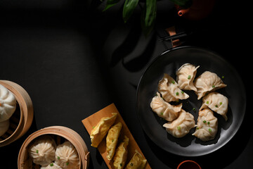 Dinning table in Chinese restaurant with Dimsum on bamboo steamer, dumplings and pork buns