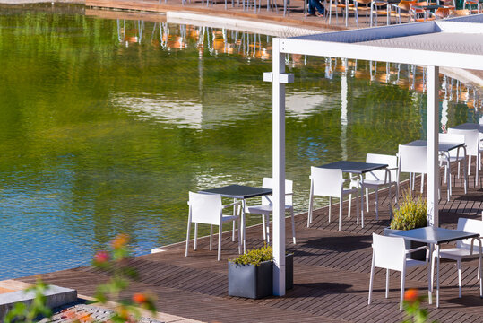 The Amalia Rodrigues Garden with a pond creating a specular reflection of an open air cafe