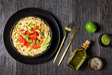 pasta with avocado, tomatoes and lime, top view