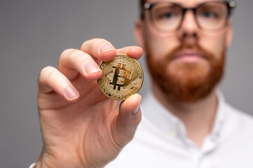 Man showing golden bitcoin investing in cryptocurrency