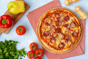 Delicious pizza with sausages on gray background
