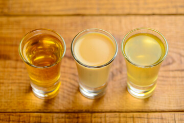 Fresh organic apple cider with apples and cinnamon over rustic wooden background. Close up three glasses.