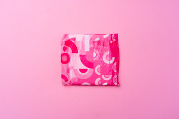 Female hygienic pad on pink background top view