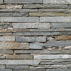rough grey slate stone wall closeup, textured pattern background