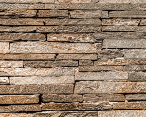 rough brown slate stone wall closeup, textured pattern background