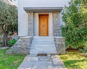 garden and white marble stairs to family house main entrance natural wood door