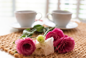 Beautiful composition for blog post in Instagram. Two cup of tea or coffee and flowers on white table with brown napkin. Free minute at work and enjoyment from rest. Close-up