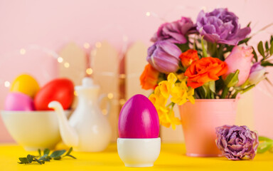Easter colorful eggs on the background of spring flowers. Bright Easter concept. Copy space.