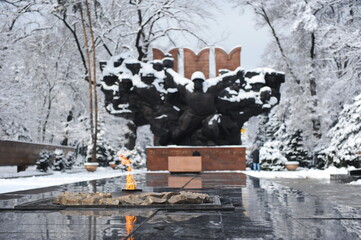 Almaty, Kazakhstan - 03.28.2010 : Eternal flame on the background of the monument to the fallen...