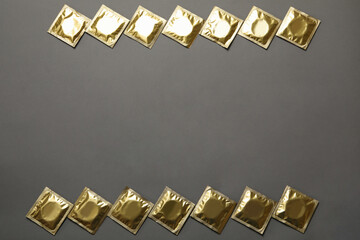 Blank condoms on gray background, space for text