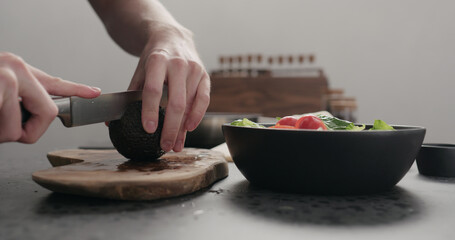 Fototapeta na wymiar man open avocado on kitchen countertop