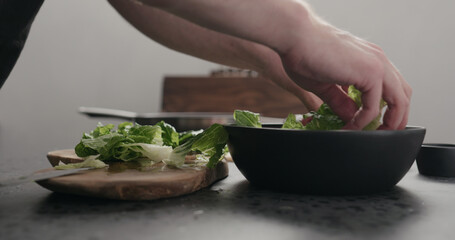 man cut romaine for salad on kitchen countertop