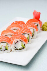 Maki Sushi - Roll made of smoked salmon and cream cheese. Traditional Japanese cuisine concept, over white background.