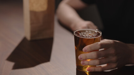 Man drink apple cider with chips on walnut table