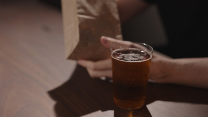Man drink apple cider with chips on walnut table