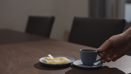 Man drink espresso with vintage cheese on walnut table