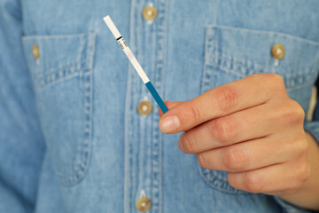 Woman hold pregnancy test strip, close up