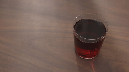 red drink in tumbler glass on walnut table with copy space