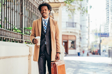 Business man holding briefcase while walking outdoors